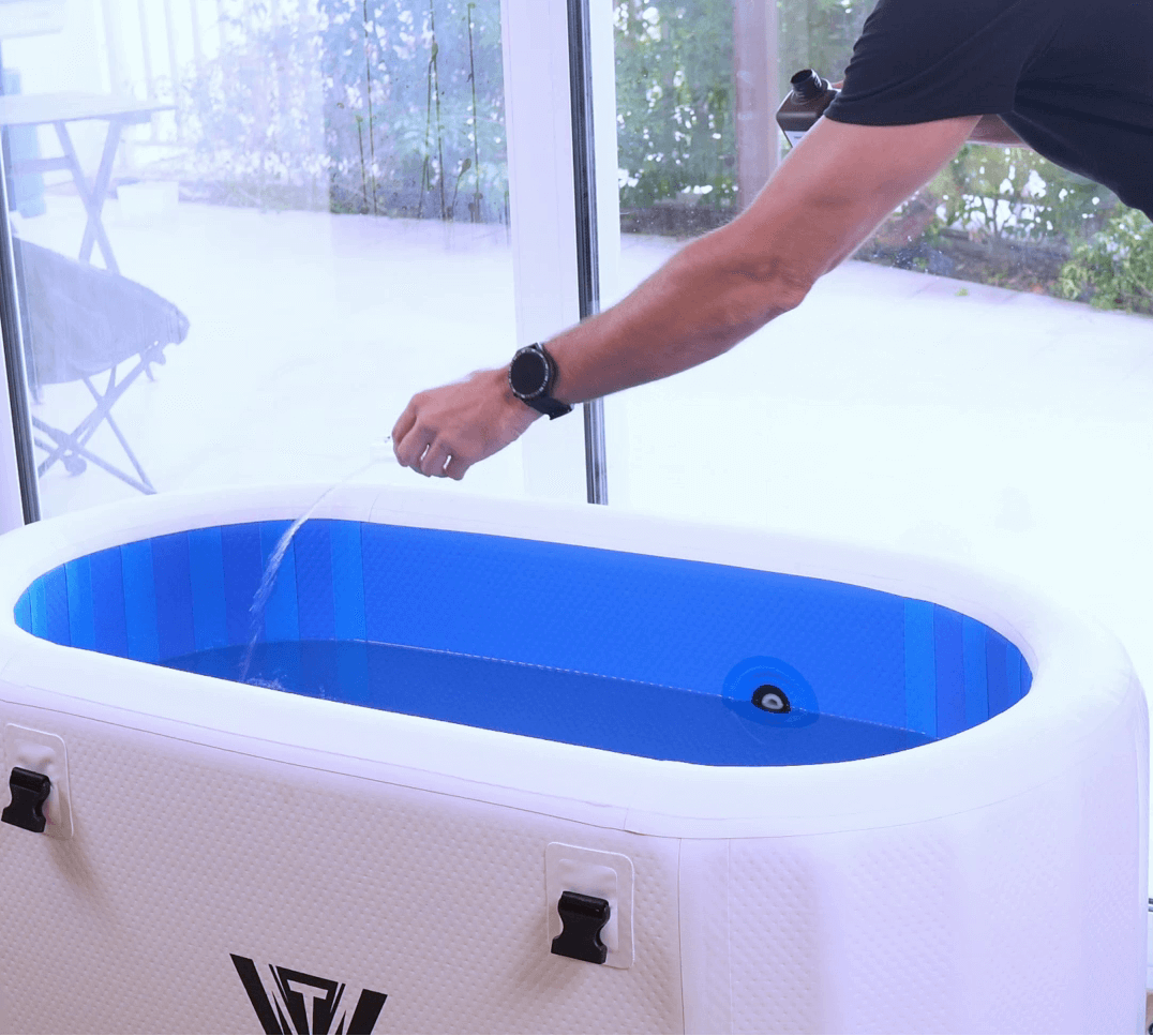 Person performing ice bath maintenance by adding cleaning solution to the water in an ice bath.