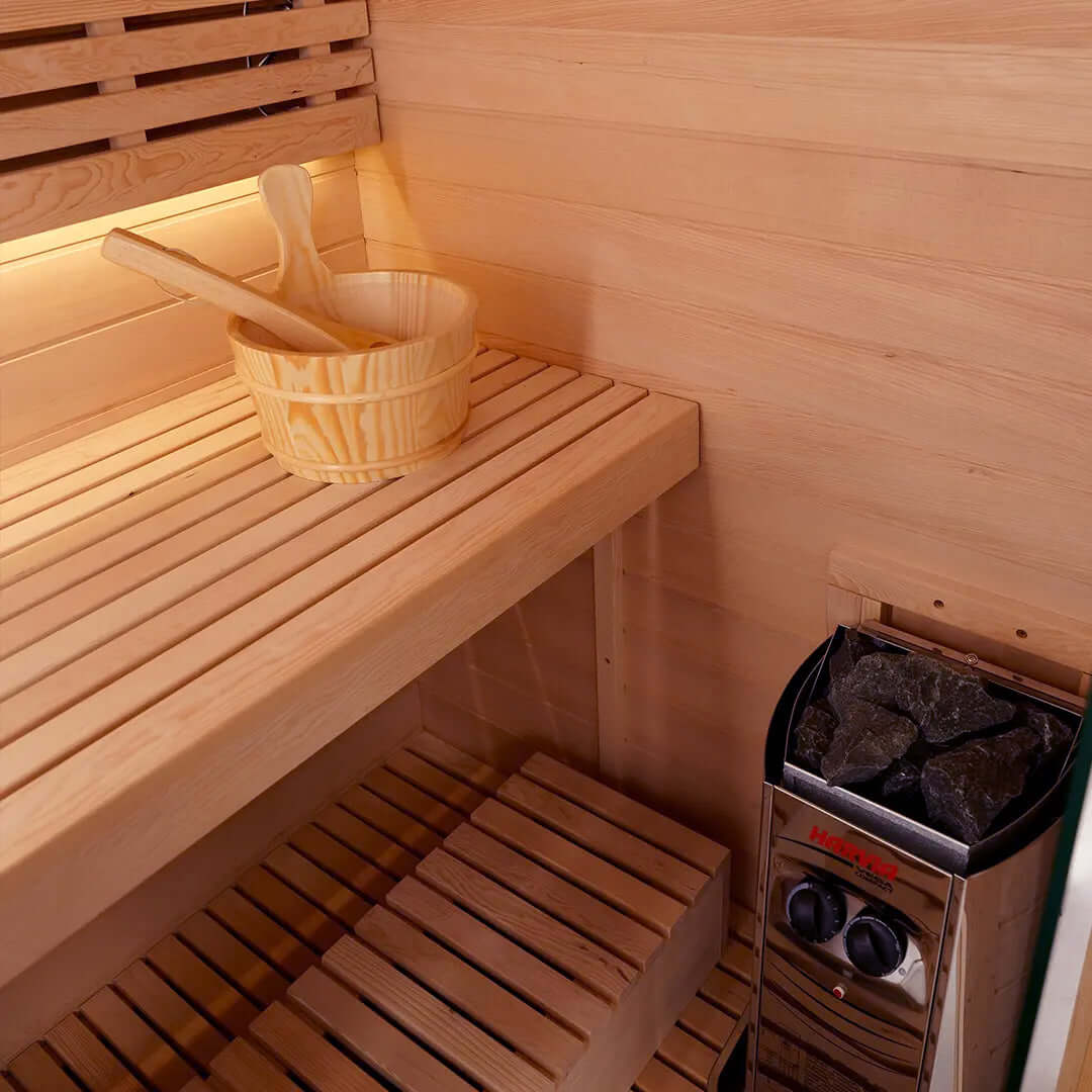 Interior view of a sauna featuring wooden benches, a bowl, and a Harvia heater.